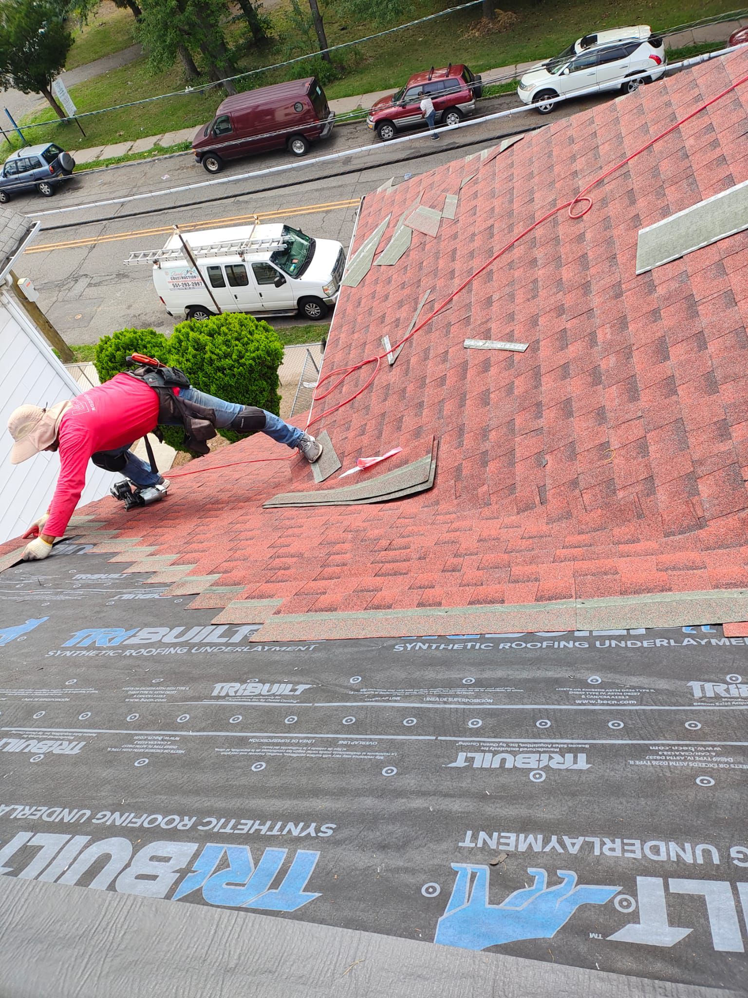 GAF certified installer setting red architectural shingles over fresh underlayment