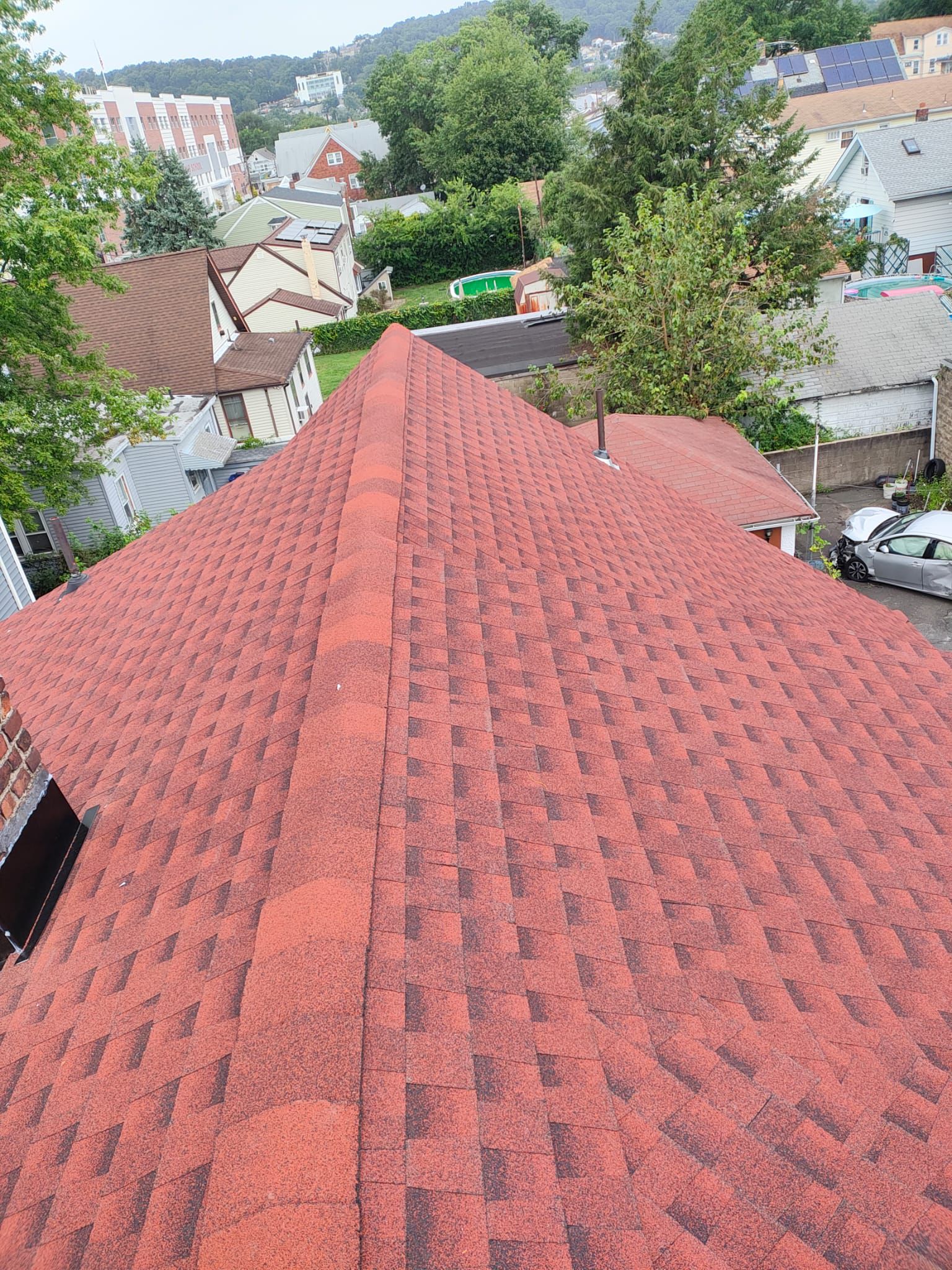 Completed red architectural asphalt shingle hip roof on a Northern NJ home