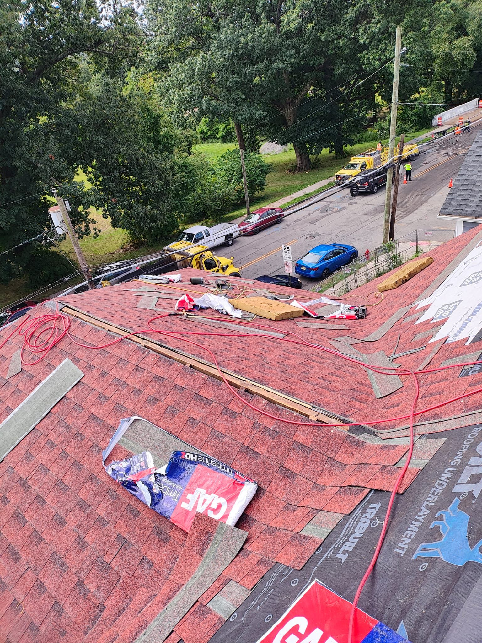 In-progress shingle installation on the steep Tudor pitch