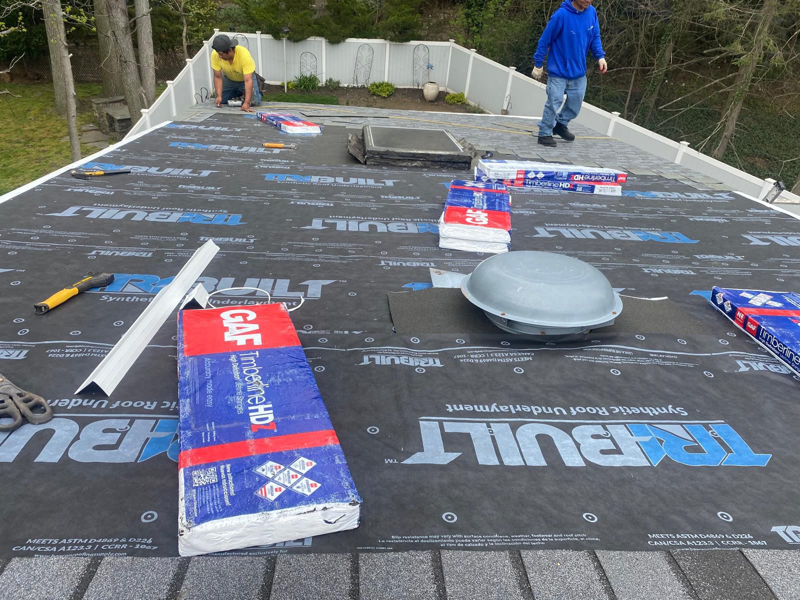Randy's Roofing Construction crew prepping a roof deck with TRIBUILT synthetic underlayment and staging GAF Timberline shingles for full replacement in Northern NJ