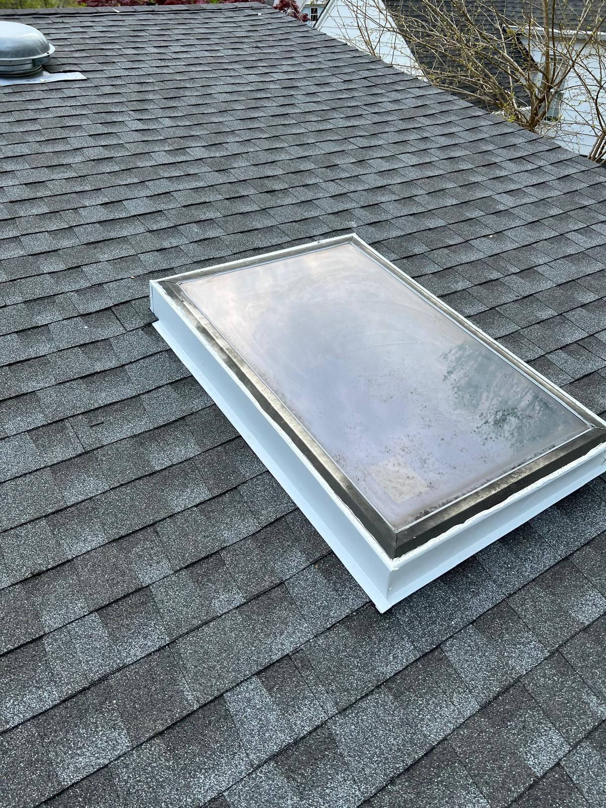 Skylight resealed with new flashing on an asphalt shingle roof