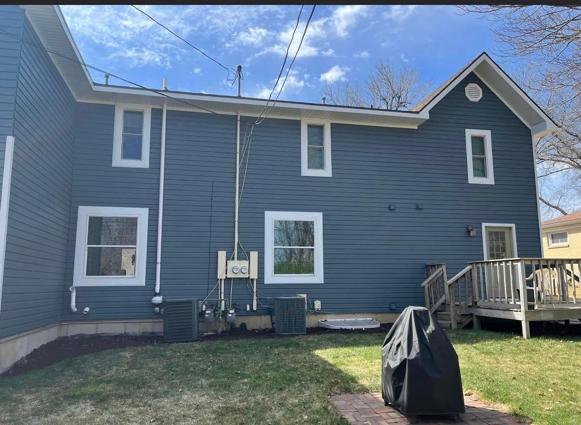 Two-story Northern NJ home wrapped in slate-gray vinyl siding with white trim by Randy's Roofing Construction