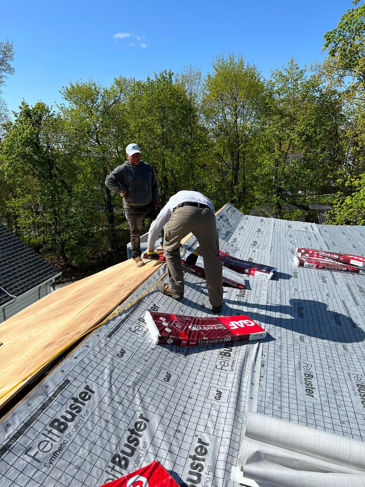 Crew laying FeltBuster underlayment on a Montclair Victorian roof
