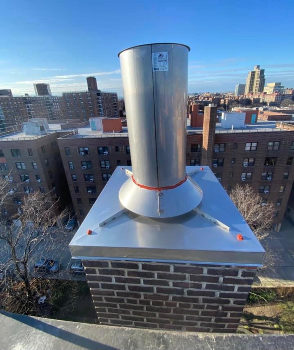 Tall stainless steel chimney liner extension installed on a rooftop chimney
