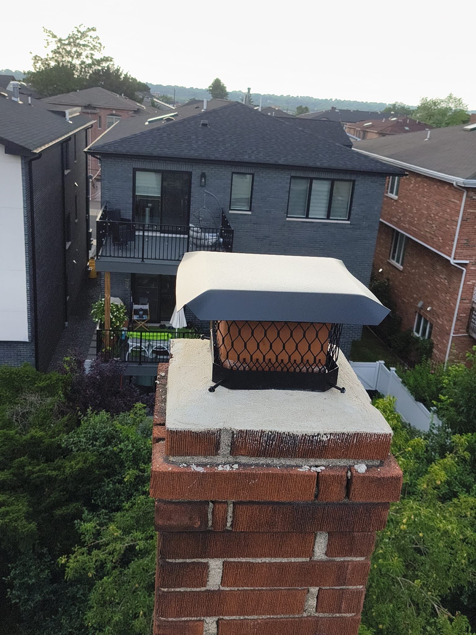 Brick chimney finished with a black stainless mesh cap