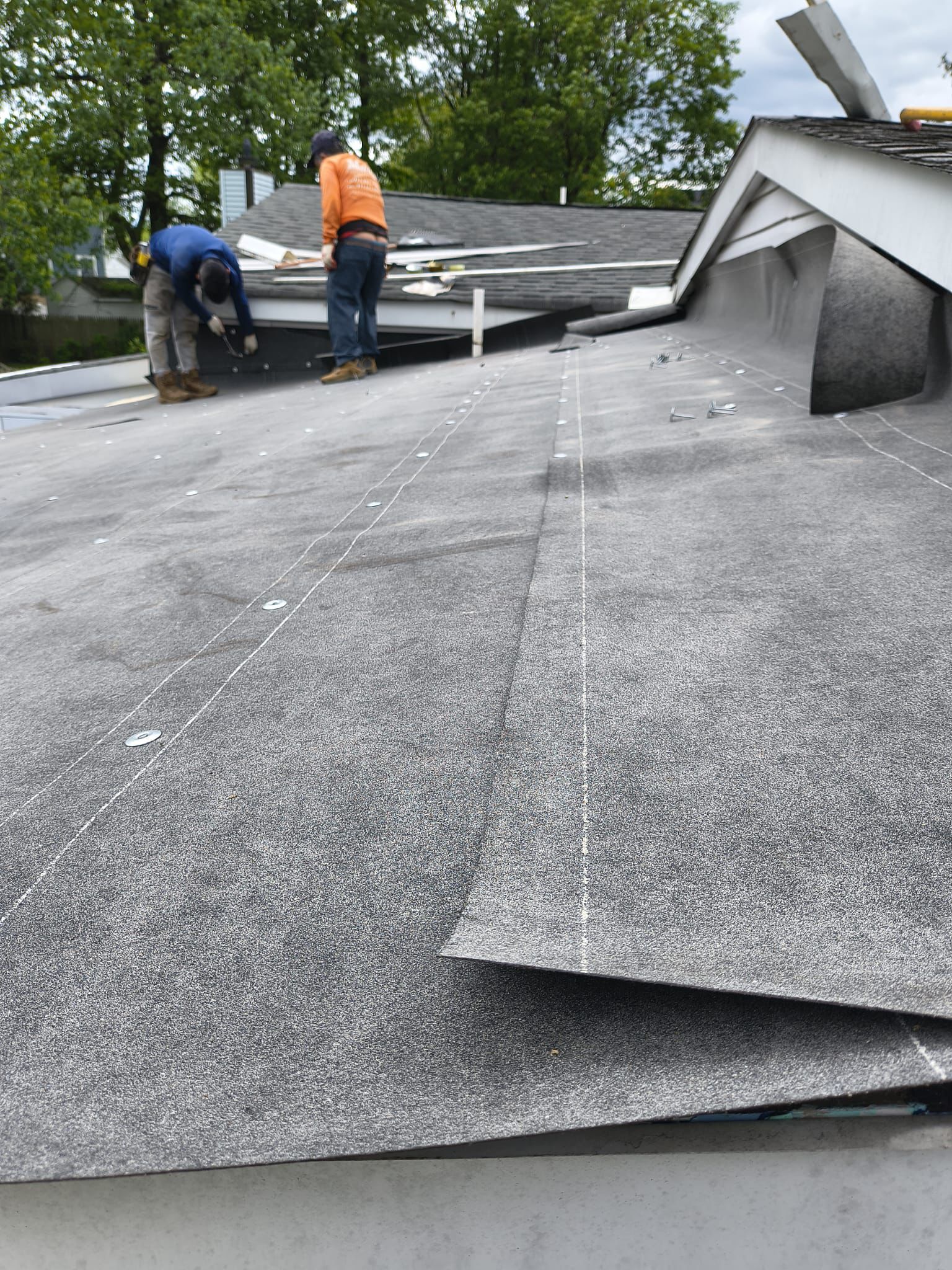 Crew working on the flat rubber roof installation