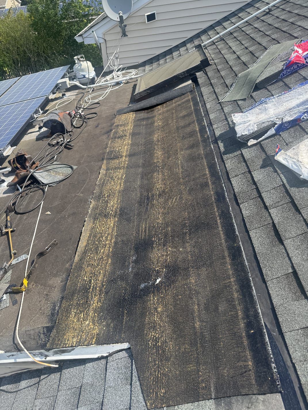 Patch repair of an asphalt shingle roof near rooftop solar panels