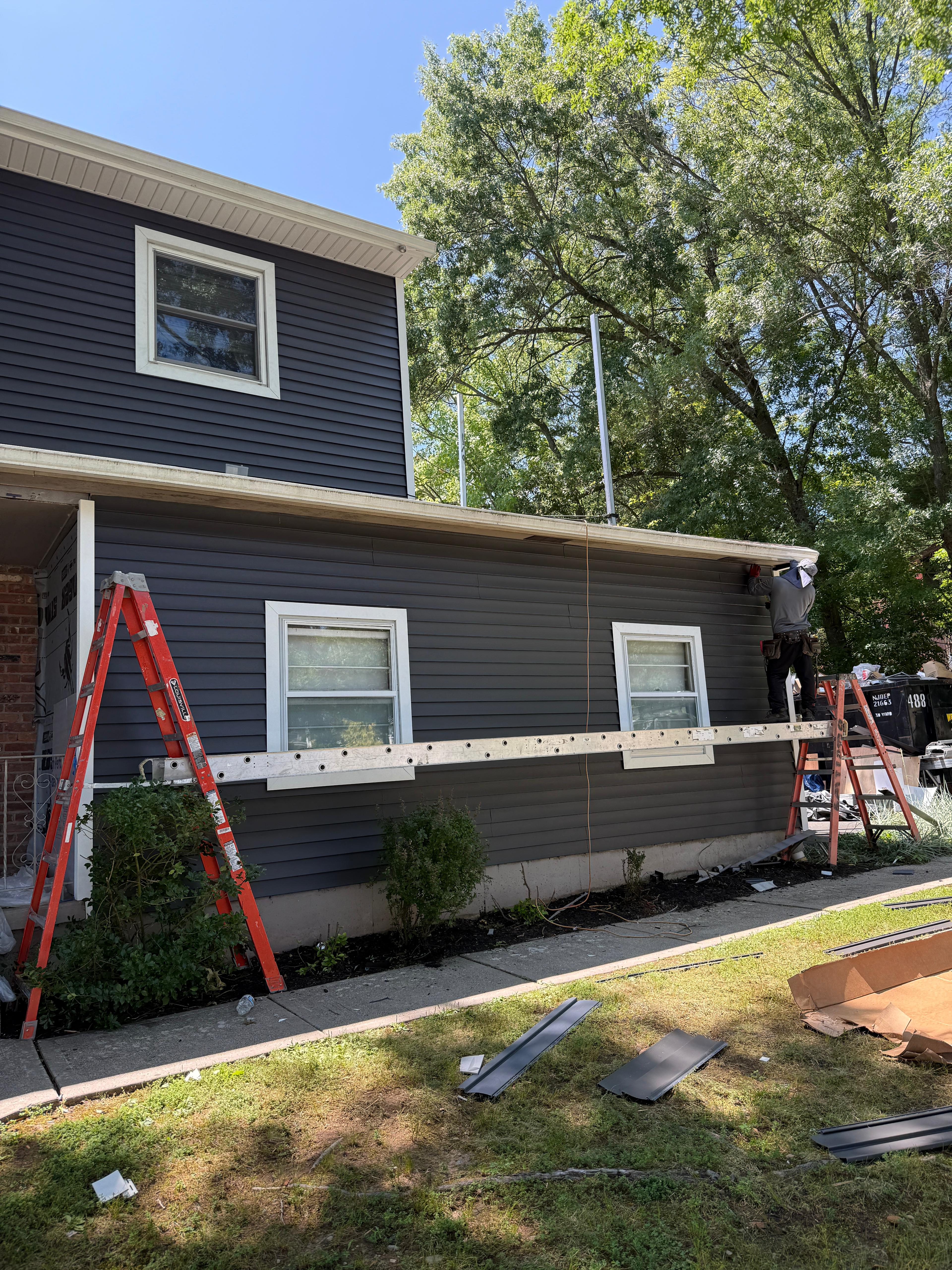 Completed front elevation with navy siding, white trim and finished soffit