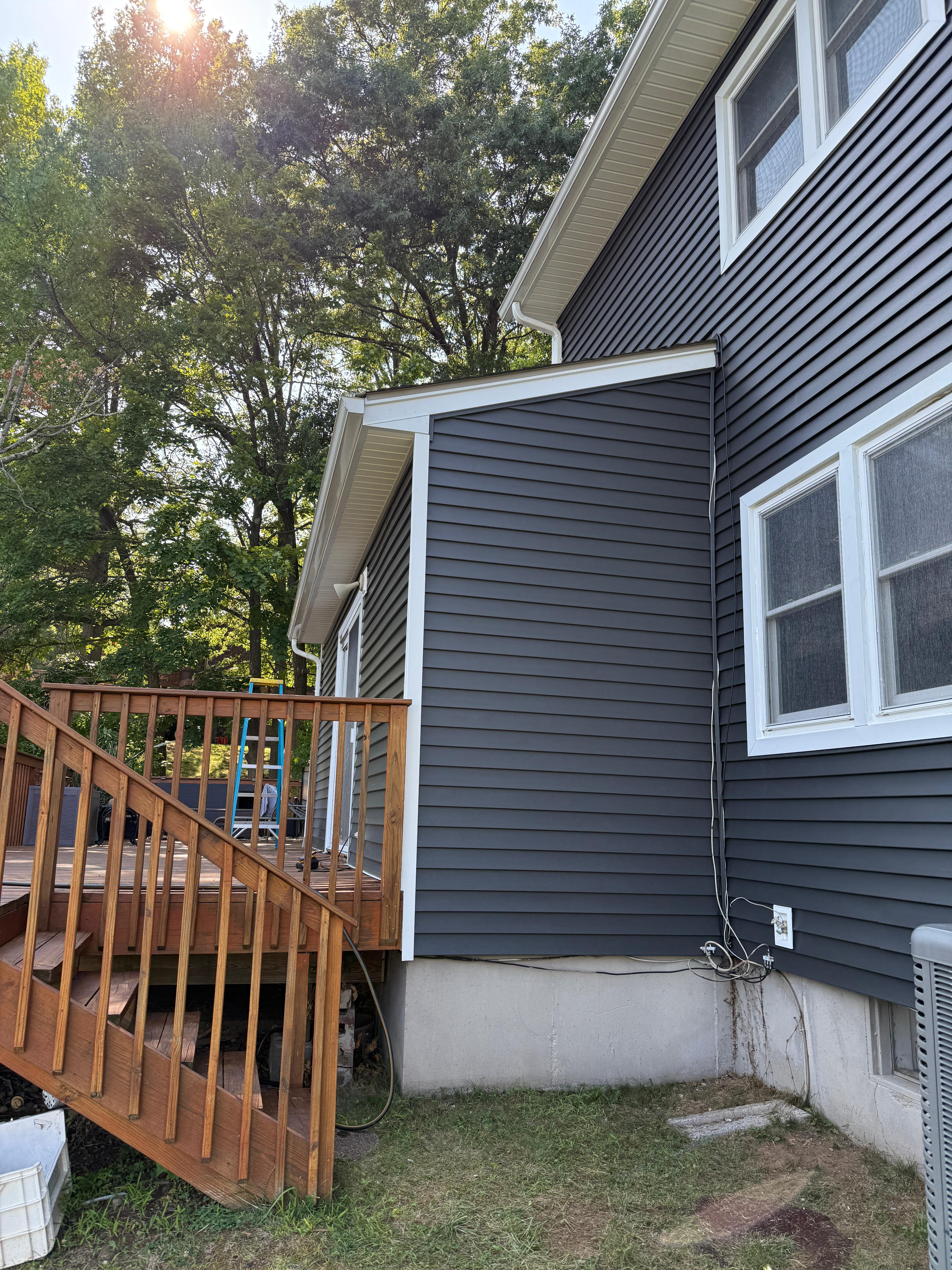 Finished siding meeting the wooden deck and stair landing
