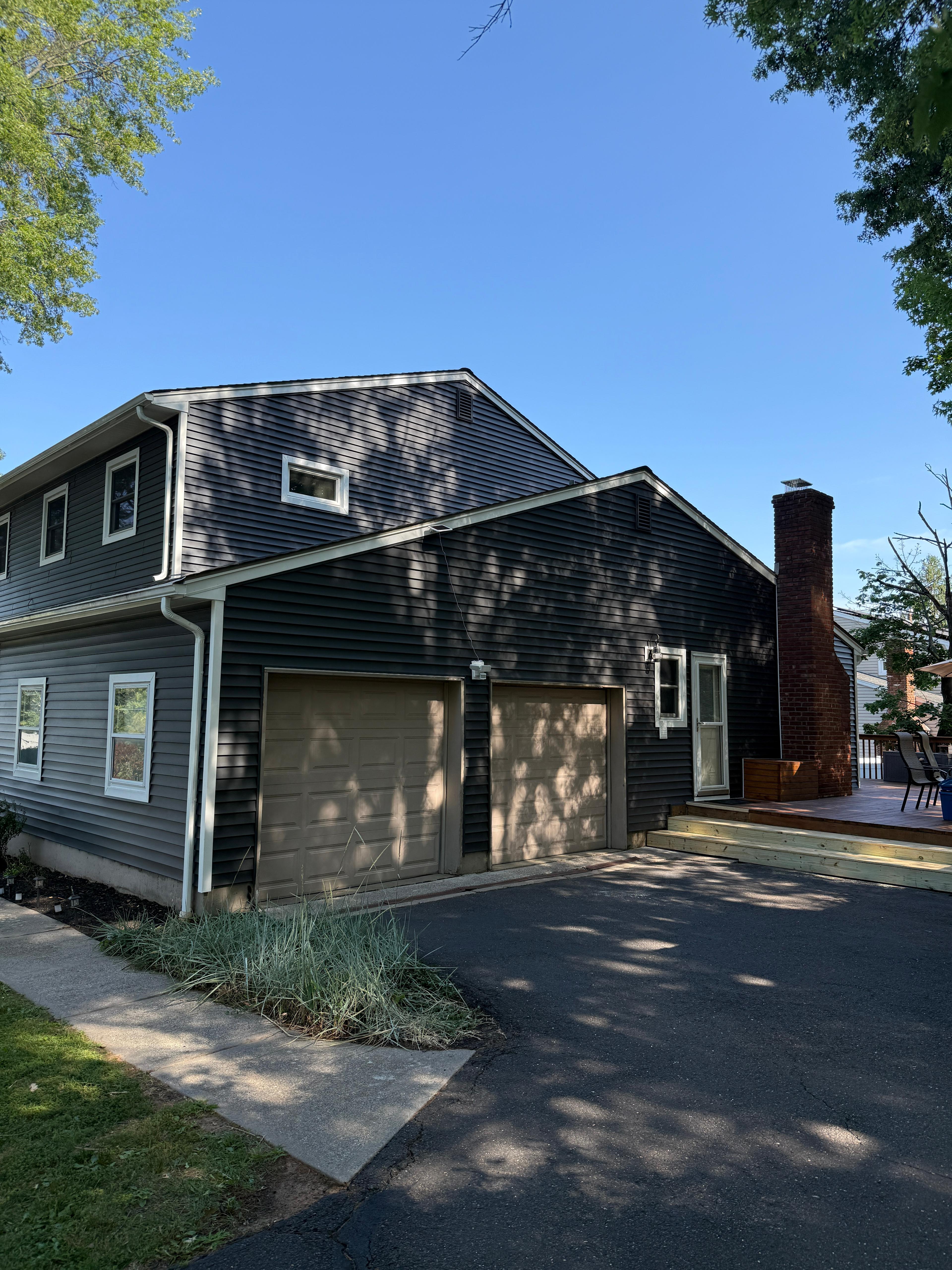 Finished garage wing and brick chimney in navy siding