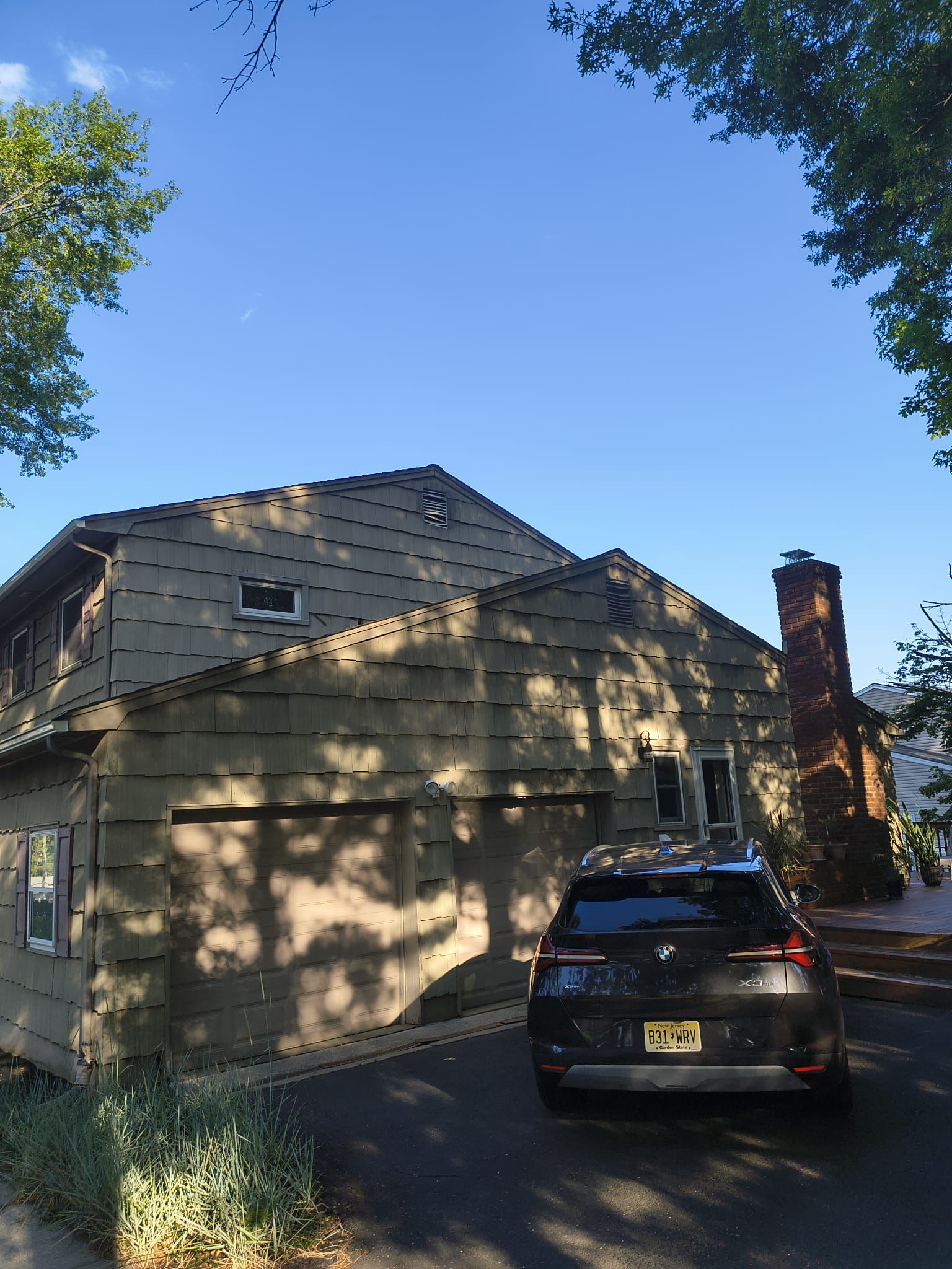 Attached two-car garage and brick chimney before residing