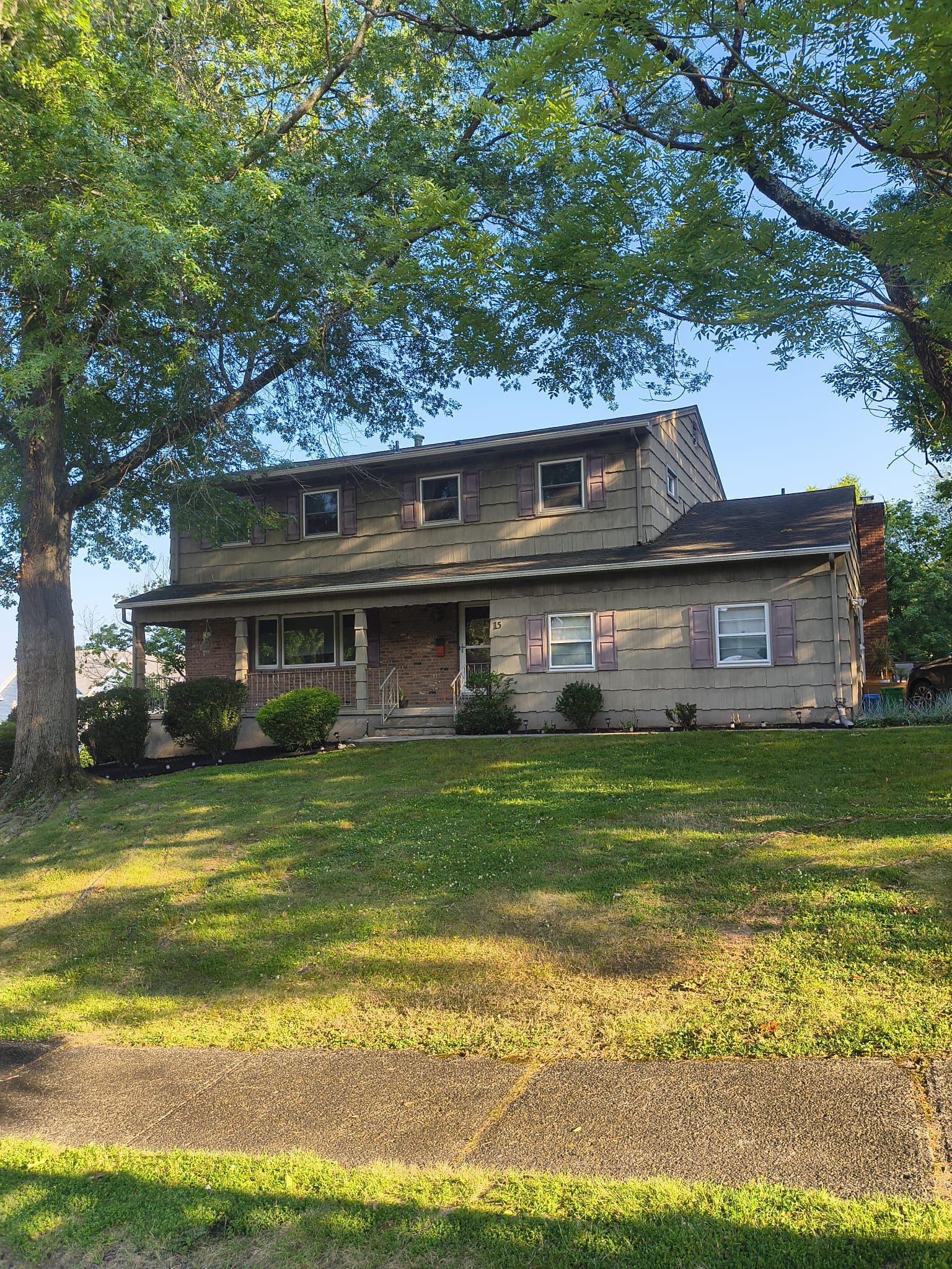 Front elevation before: home clad in weathered tan cedar shake with mauve shutters