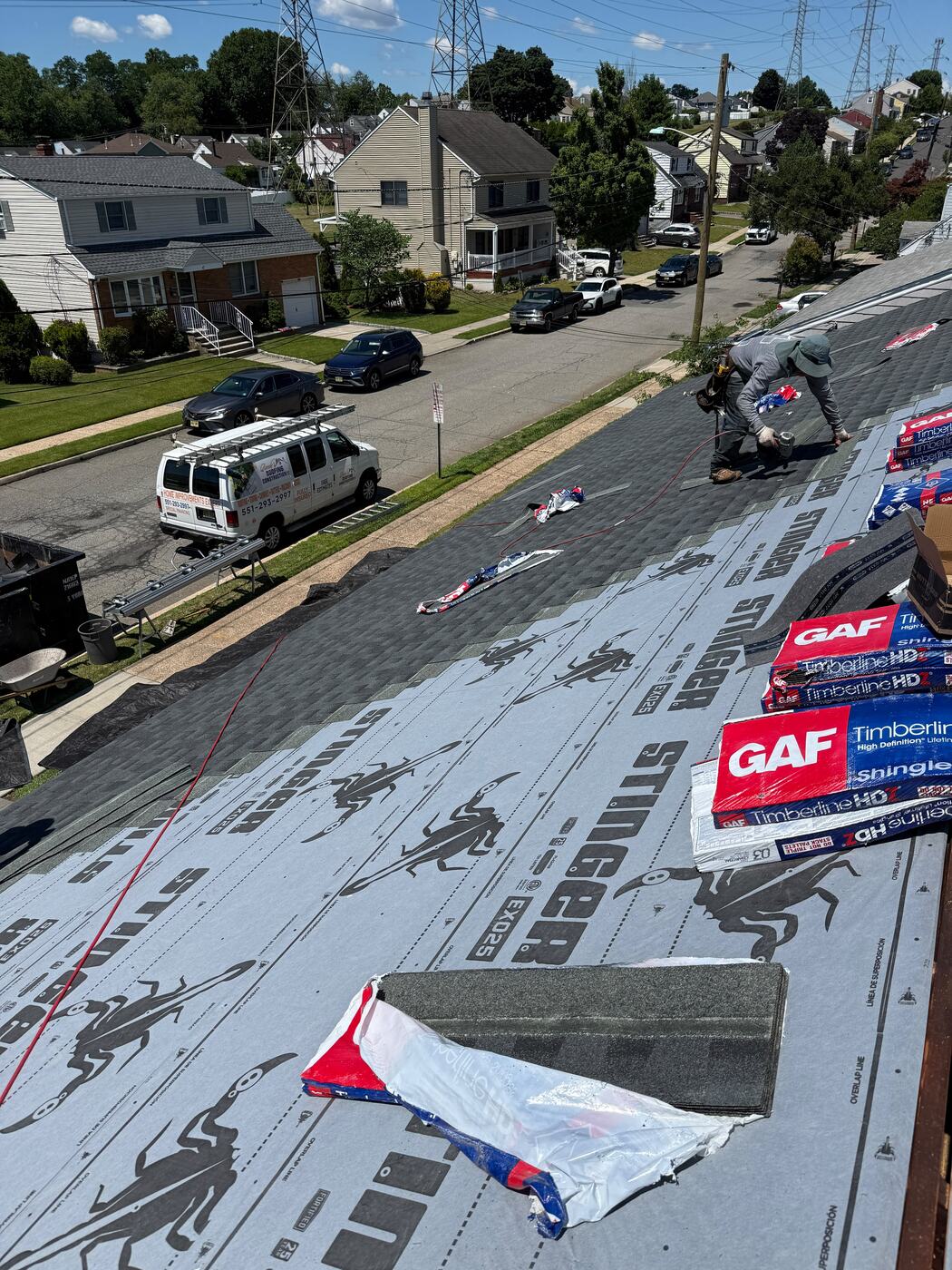 Stinger EXO25 synthetic underlayment rolled across the deck with the Randy's Roofing van staged on the street below