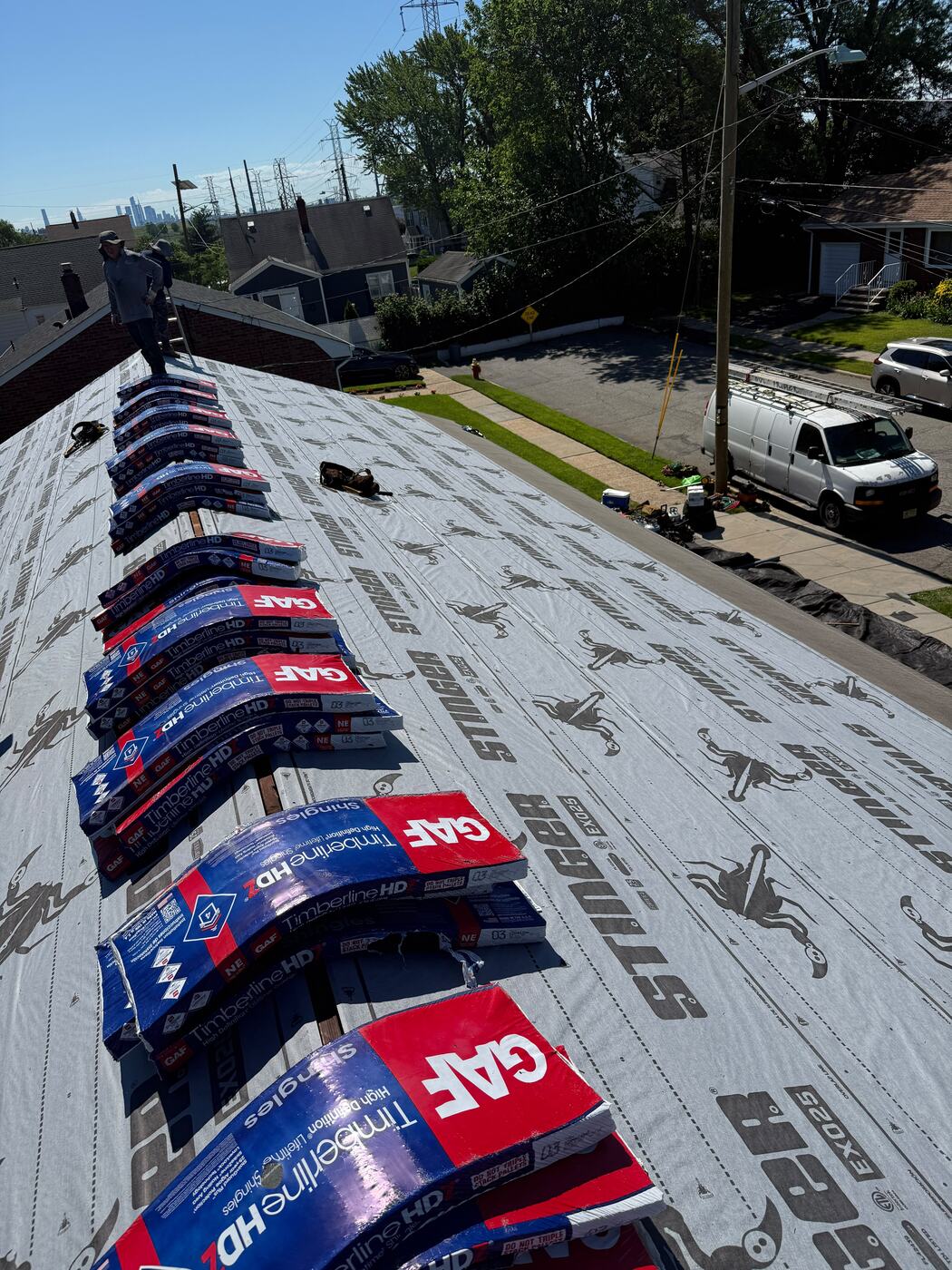 GAF Timberline HDZ shingle bundles staged in a row along the ridge over fresh underlayment